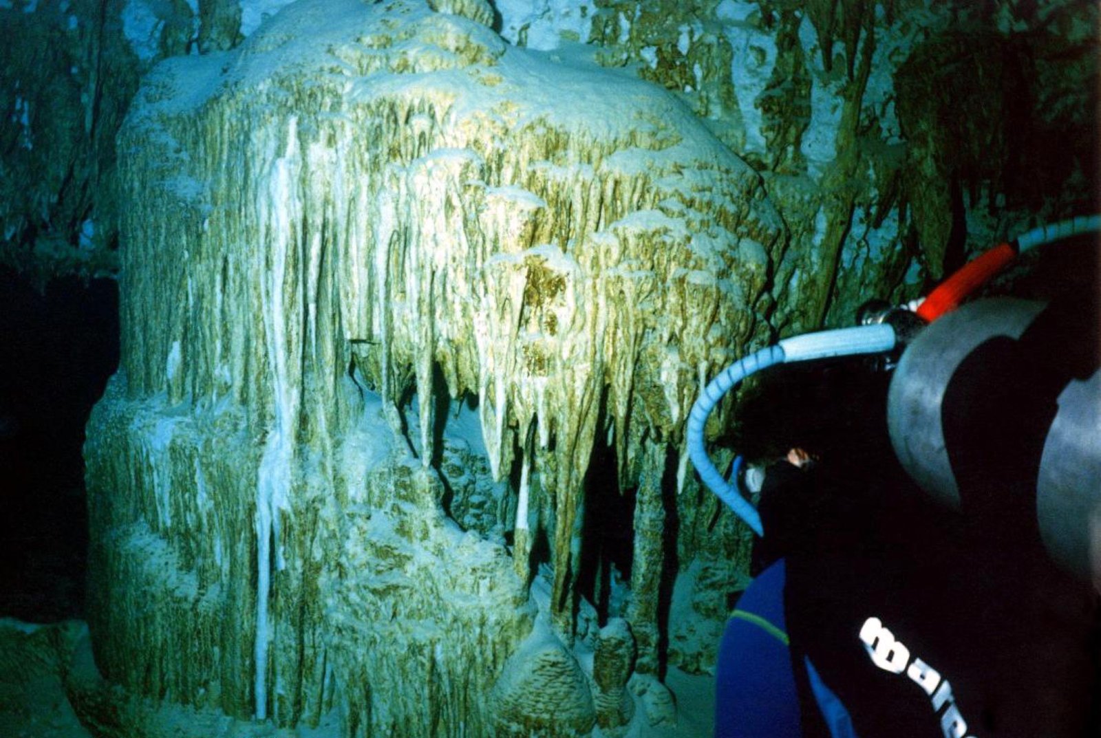 Buzo en la caverna de Dos Ojos con rayos de luz adelante